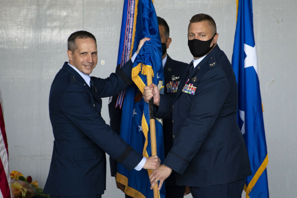 Col. Douglas A. Stouffer accepts the 512th Airlift Wing organizational flag from Maj. Gen. Jeffrey Pennington, 4th Air Force commander, during an assumption of command ceremony Oct. 16, 2021, at Dover Air Force Base, Del. The passing of the flag signifies the start of Stouffer’s command of the wing. (U.S. Air Force photo by Tech. Sgt. Zachary Cacicia)