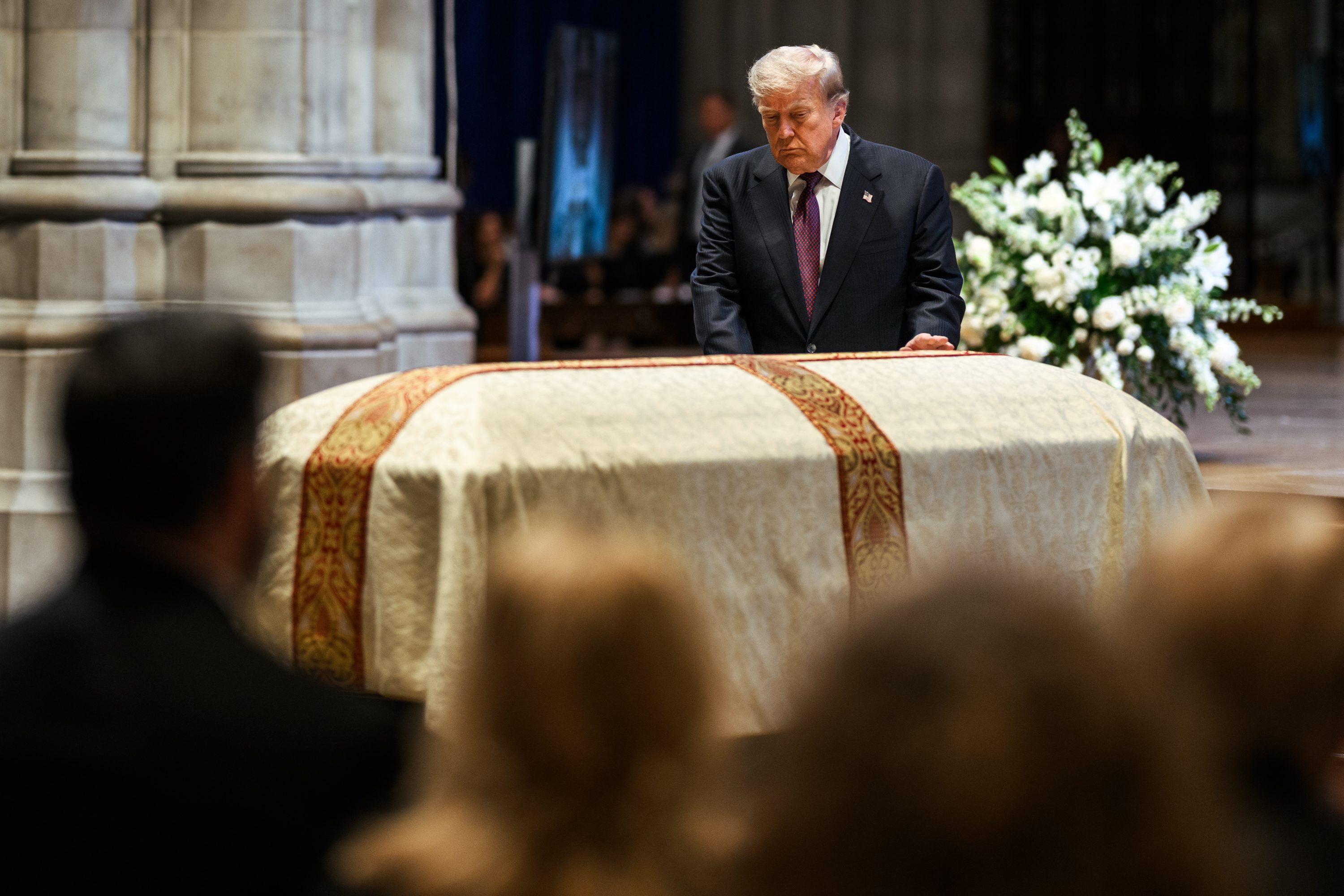 President Donald J. Trump stands beside the casket during Senator Lindsey Graham's funeral service at Washington National Cathedral.