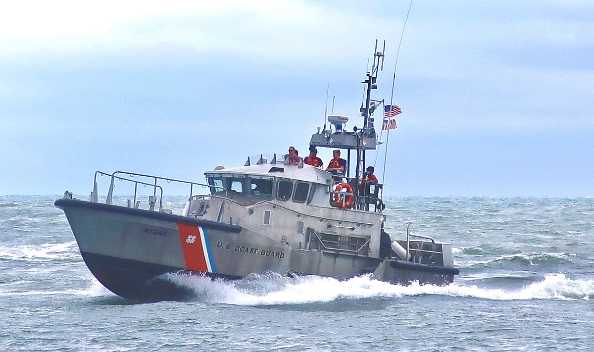 A United States Coast Guard boat underway in rough water near Indian River Inlet.