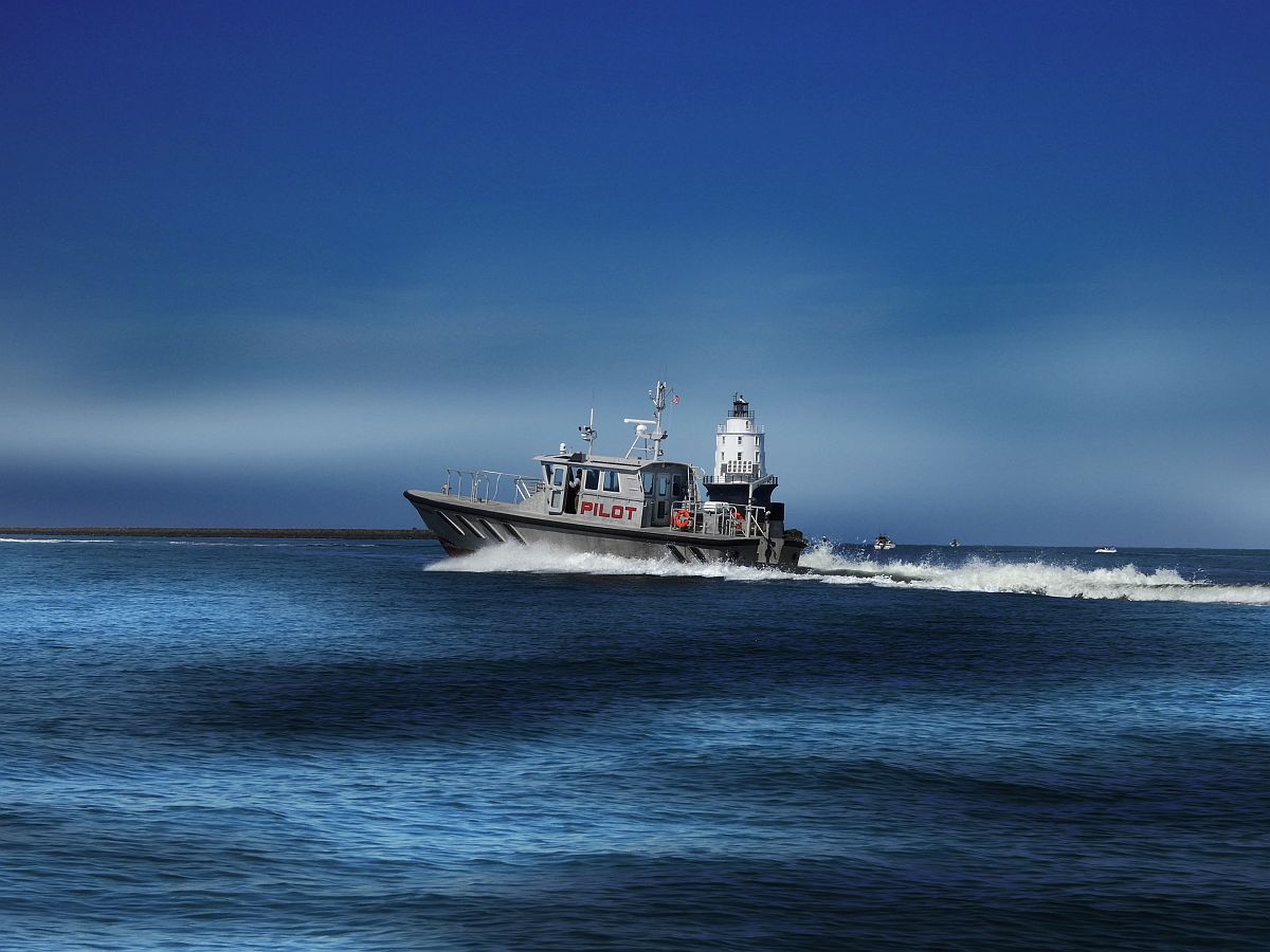 Pilot boat passing Harbor of Refuge Lighthouse