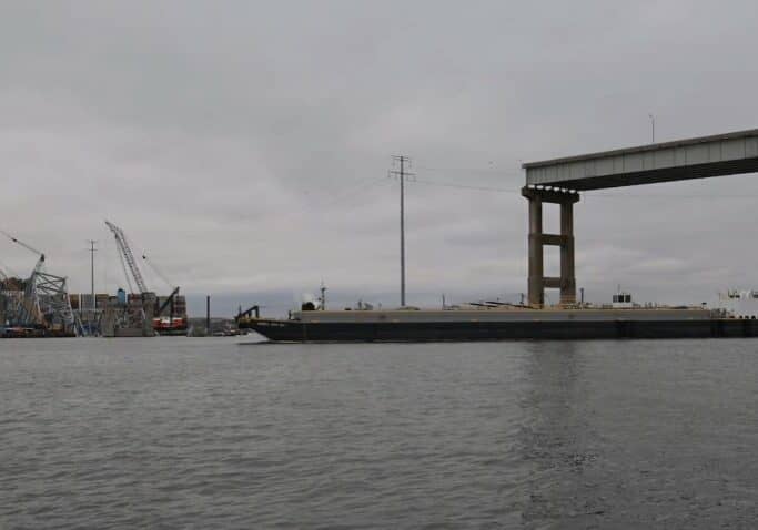 The tugboat Crystal Coast pushes a fuel barge through the temporary alternate channel created by the Key Bridge Response Unified Command, near the Key Bridge incident, in Baltimore, Maryland, April 1, 2024. The Crystal Coast is the first vessel to use the channel since the bridge collapsed into the federal waterway on March 26th. (U.S. Coast Guard video by Petty Officer 2nd Class Taylor Bacon)