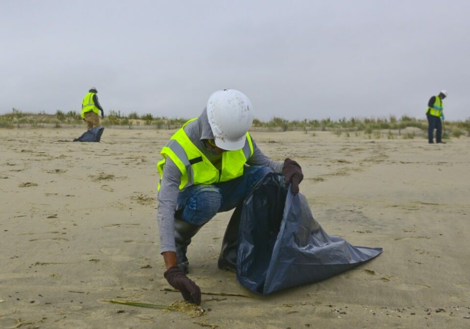 Members of a contracted oil spill response organization cleans oily debris from Rehoboth Beach in Delaware as part of the Broadkill 2020 oil spill response, Oct. 26, 2020. The Coast Guard and the Delaware Department of Natural Resources and Environmental Control are working together to identify areas where tar balls and oily debris are making landfall to facilitate an effective clean up.(U.S. Coast Guard photo by Petty Officer 3rd Class Isaac Cross.)
