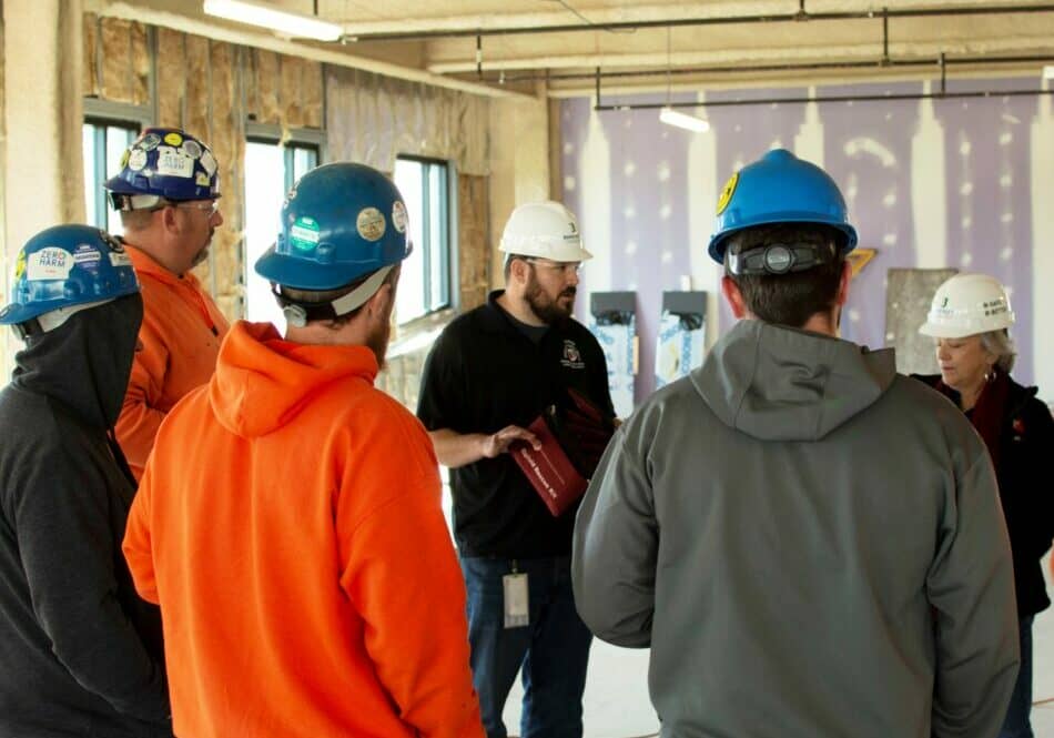 John Robinson (left) and Anne Carr of the DPH Office of Health Crisis Response train a group of Bancroft Construction workers Nov. 18, on the use of Narcan, a medication that can reverse the effects of opioids in an overdose situation and can potentially save a life. DPH has partnered with the construction industry to provide substance use disorder resources and training for workers.