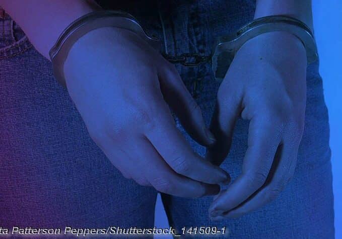 Young Women in Handcuffs with red and blue lighting © Anita Patterson Peppers/Shutterstock_141509-1
