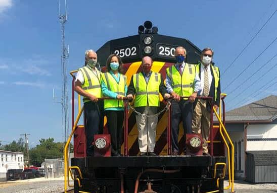 From left: Delaware Department of Agriculture Secretary Michael Scuse, Congresswoman Lisa Blunt Rochester, U.S. Senator Chris Coons, U.S. Senator Tom Carper and Carload Express President and CEO Mark Rosner celebrate an $18.8 million grant award from the U.S. Department of Transportation to Delmarva Central Railroad to fix its 188 miles of rail and bridges from Delaware to Virginia.
